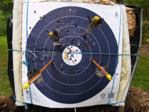 Four fletched arrow and a bareshaft impacting an NFAA target